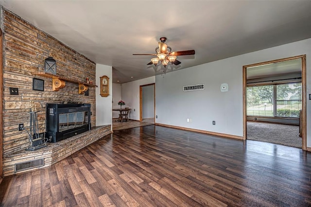 unfurnished living room with ceiling fan, a large fireplace, a baseboard heating unit, and hardwood / wood-style flooring