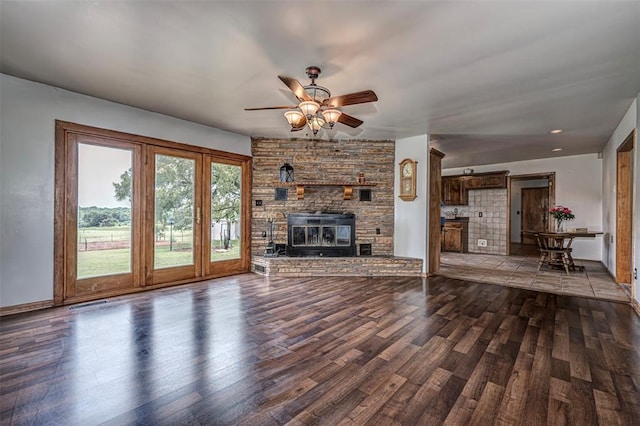 unfurnished living room with ceiling fan, a fireplace, and hardwood / wood-style flooring