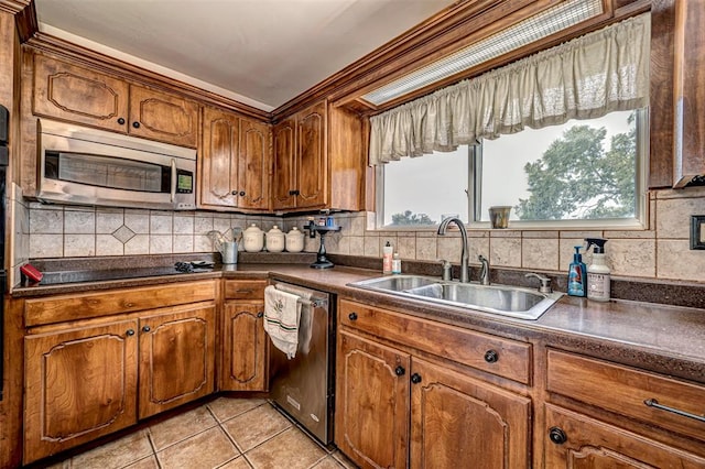 kitchen featuring light tile patterned flooring, stainless steel appliances, a wealth of natural light, and sink