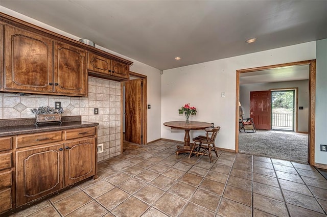 kitchen with decorative backsplash and light colored carpet