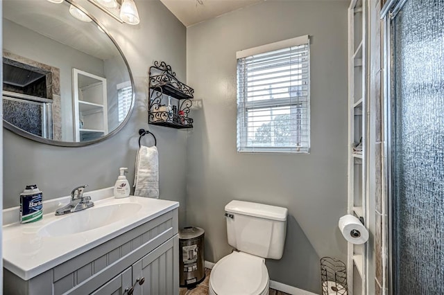 bathroom with a shower with door, vanity, and toilet