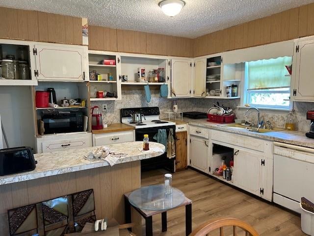 kitchen with black appliances, light hardwood / wood-style floors, white cabinets, and tasteful backsplash