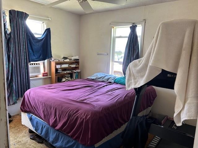 bedroom with carpet, a textured ceiling, ceiling fan, and cooling unit