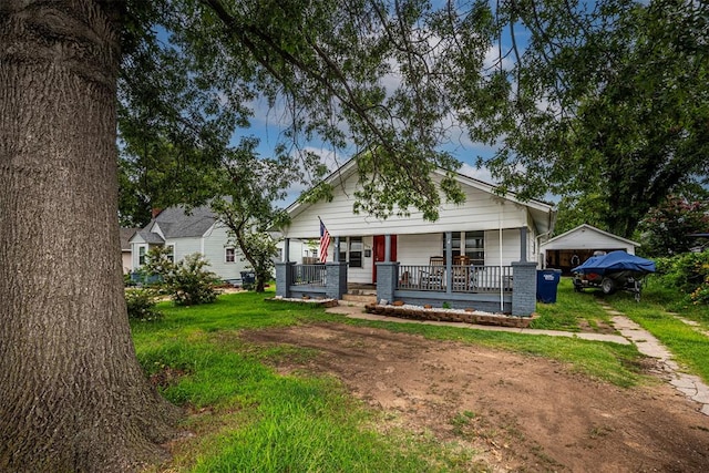 bungalow with covered porch and a front yard