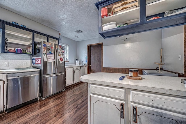 kitchen featuring a textured ceiling, white cabinetry, stainless steel appliances, and dark hardwood / wood-style floors