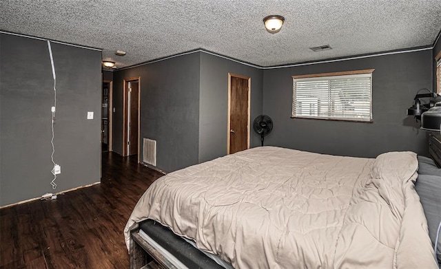 bedroom with a closet, crown molding, dark hardwood / wood-style flooring, and a textured ceiling