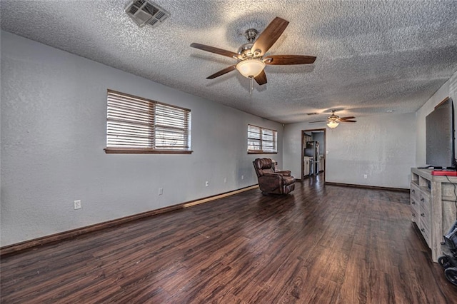 unfurnished room with ceiling fan, dark wood-type flooring, and a textured ceiling