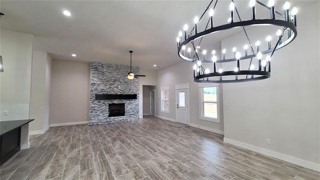 unfurnished living room featuring a stone fireplace, ceiling fan, and hardwood / wood-style flooring