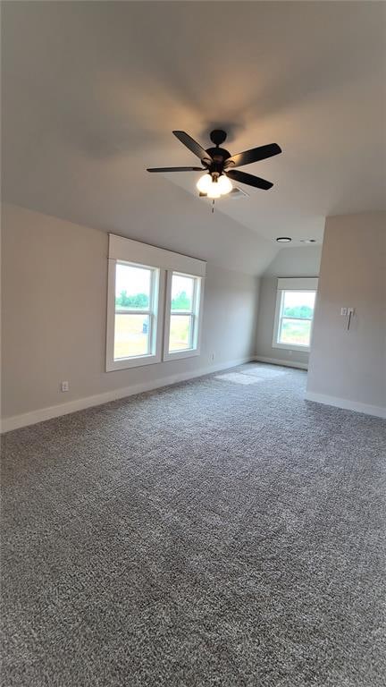 carpeted empty room with ceiling fan and vaulted ceiling