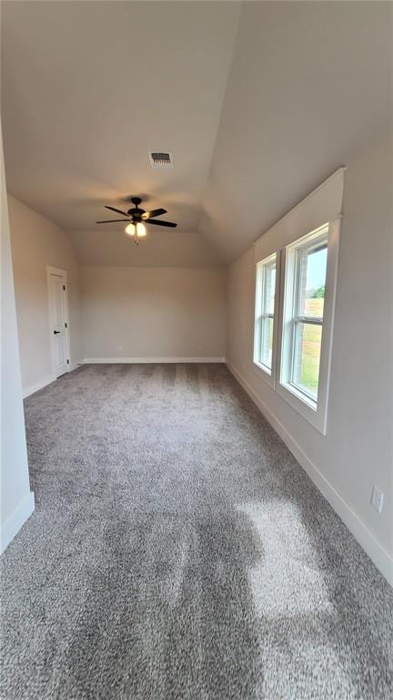 empty room featuring ceiling fan, carpet, and lofted ceiling