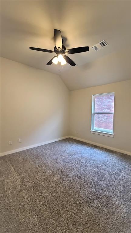 carpeted empty room with ceiling fan and vaulted ceiling