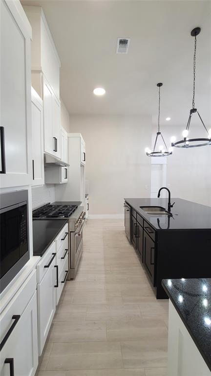 9304 SW 35th St, Oklahoma City, OK 73179 - kitchen with a sink, appliances with stainless steel finishes, baseboards, white cabinets, and recessed lighting
