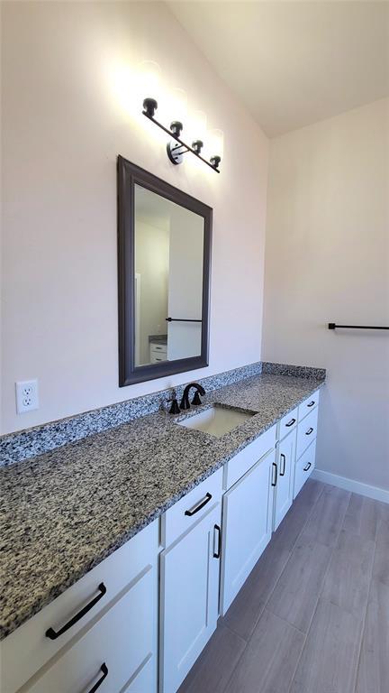 9304 SW 35th St, Oklahoma City, OK 73179 - bathroom featuring vanity, wood finished floors, and baseboards