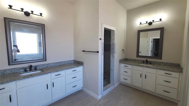 9304 SW 35th St, Oklahoma City, OK 73179 - bathroom with two vanities, a shower stall, wood finished floors, and baseboards