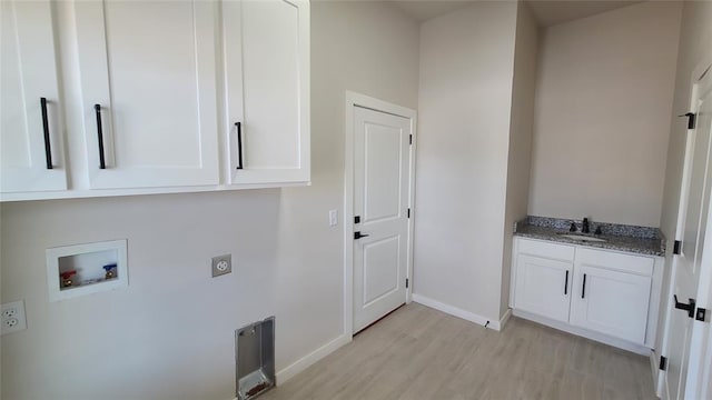 laundry room with sink, cabinets, hookup for an electric dryer, hookup for a washing machine, and light wood-type flooring