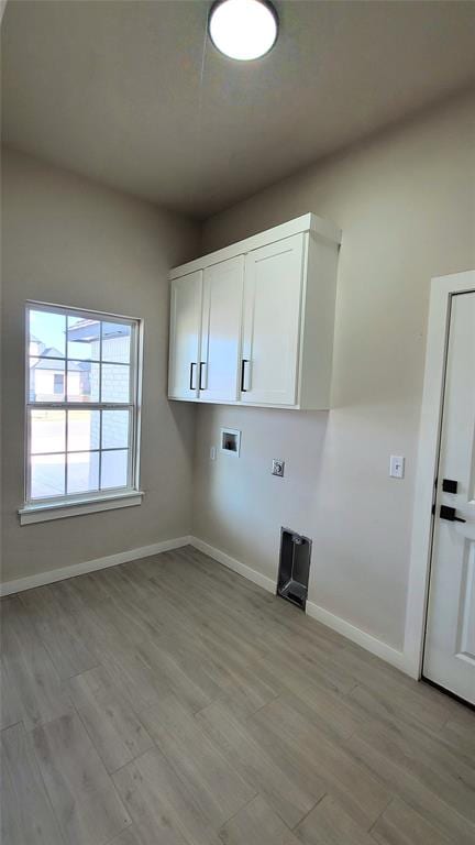 laundry area featuring hookup for a washing machine, cabinets, and light hardwood / wood-style floors