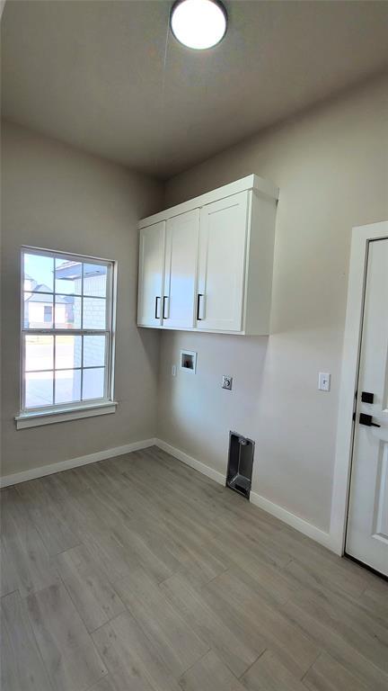 9304 SW 35th St, Oklahoma City, OK 73179 - washroom featuring cabinet space, washer hookup, baseboards, and light wood-style flooring