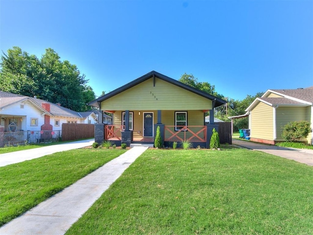 bungalow-style home with covered porch and a front lawn