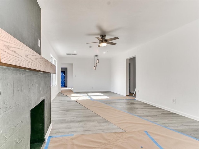 unfurnished living room featuring light hardwood / wood-style floors and ceiling fan