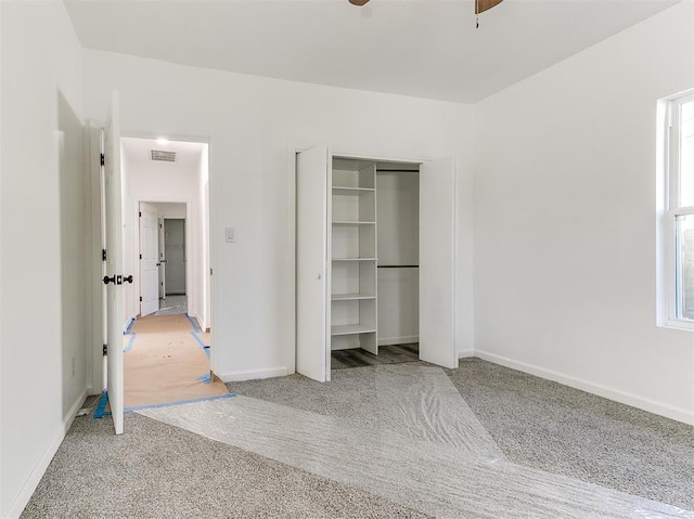 unfurnished bedroom with ceiling fan, light colored carpet, and a closet