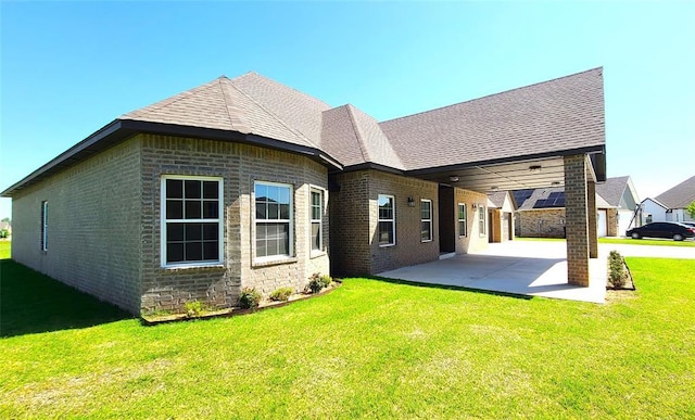 109 Tralee Ct, Yukon, OK 73099 - rear view of house with a patio, a lawn, brick siding, and roof with shingles