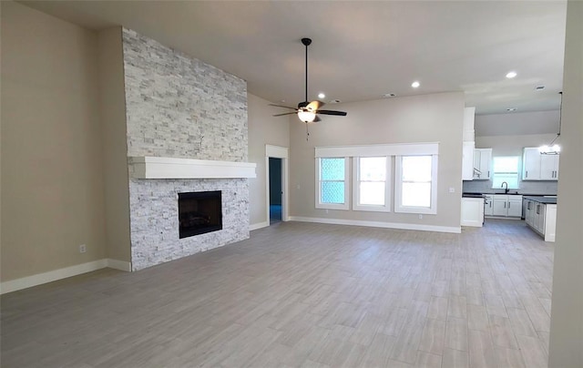 109 Tralee Ct, Yukon, OK 73099 - unfurnished living room with ceiling fan, a sink, plenty of natural light, a fireplace, and recessed lighting