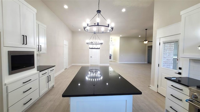 109 Tralee Ct, Yukon, OK 73099 - kitchen with dark countertops, a chandelier, a center island, recessed lighting, and stainless steel appliances