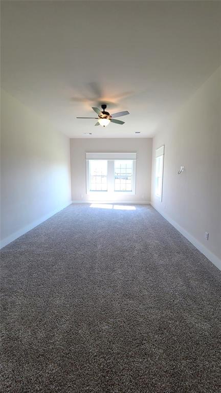 unfurnished room with carpet flooring and ceiling fan