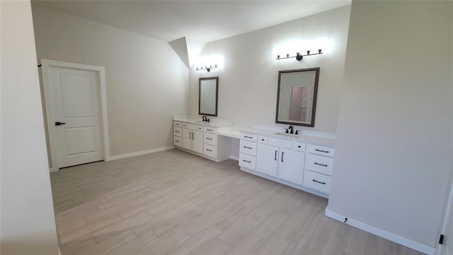 109 Tralee Ct, Yukon, OK 73099 - bathroom with baseboards, two vanities, and wood finished floors