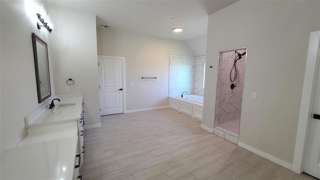 109 Tralee Ct, Yukon, OK 73099 - bathroom with a bath, double vanity, a tile shower, wood finished floors, and baseboards