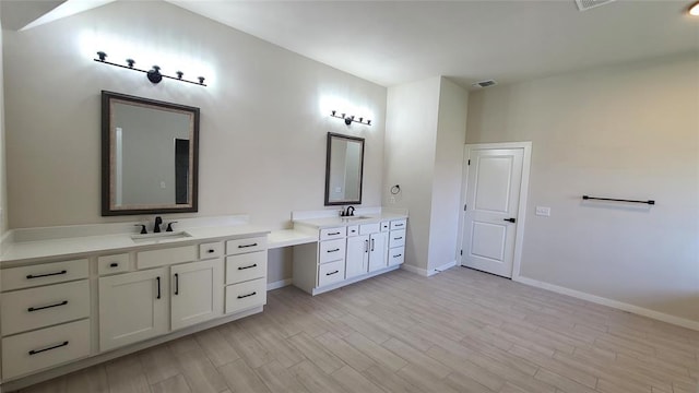 109 Tralee Ct, Yukon, OK 73099 - bathroom with two vanities, baseboards, and wood finished floors