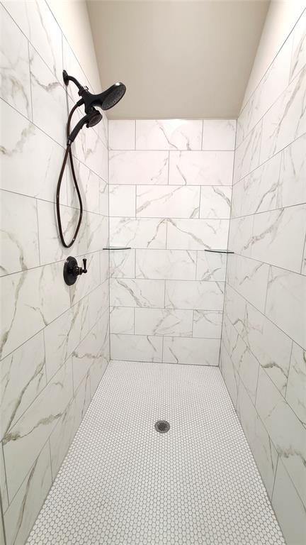 bathroom featuring a tile shower and vaulted ceiling