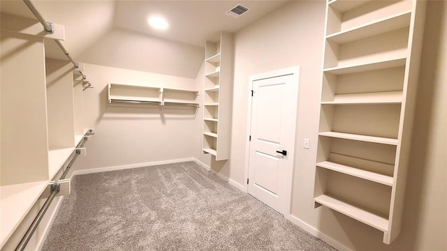 walk in closet featuring carpet flooring and vaulted ceiling