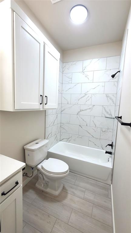 full bathroom with vanity, toilet, and tiled shower / bath combo