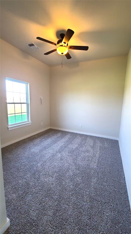 carpeted empty room featuring ceiling fan