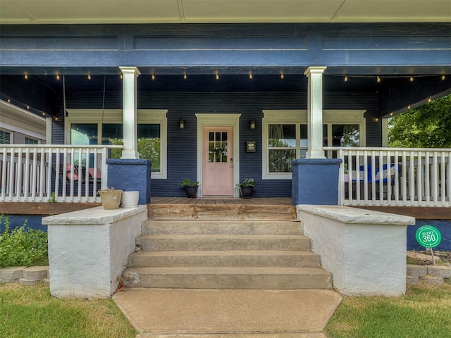 view of exterior entry featuring covered porch