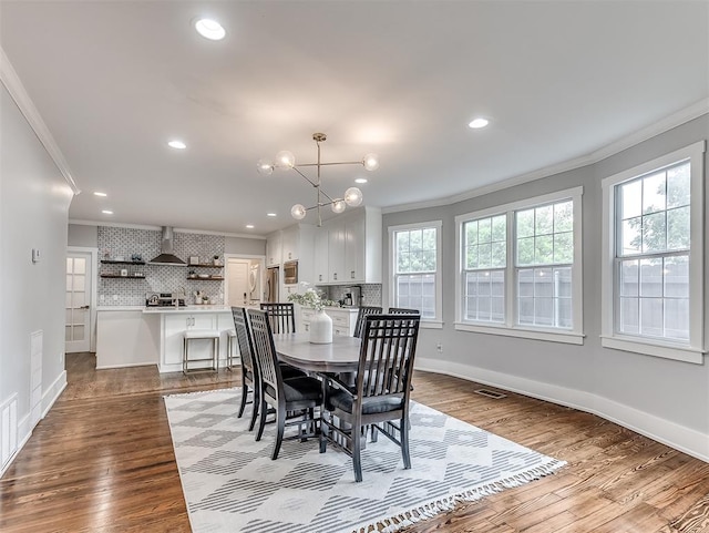 dining room featuring plenty of natural light, ornamental molding, and light hardwood / wood-style flooring