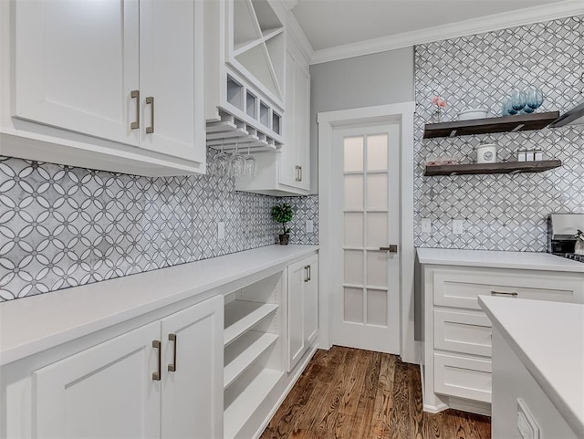 kitchen featuring decorative backsplash, white cabinetry, and ornamental molding