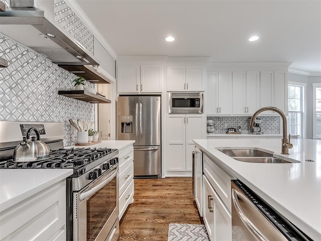 kitchen with sink, appliances with stainless steel finishes, hardwood / wood-style floors, white cabinets, and ornamental molding