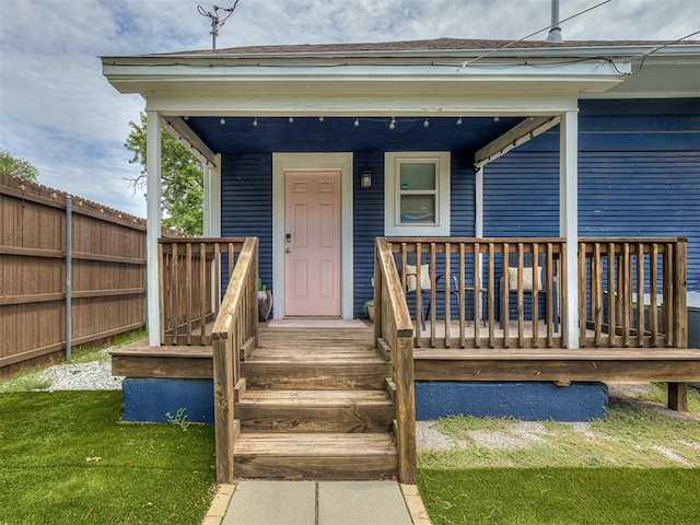 property entrance with a porch and a lawn