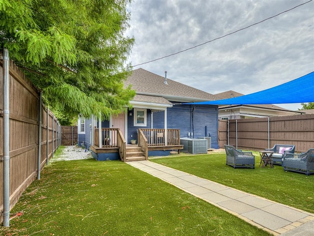 rear view of house with an outdoor living space, a yard, a wooden deck, and central air condition unit