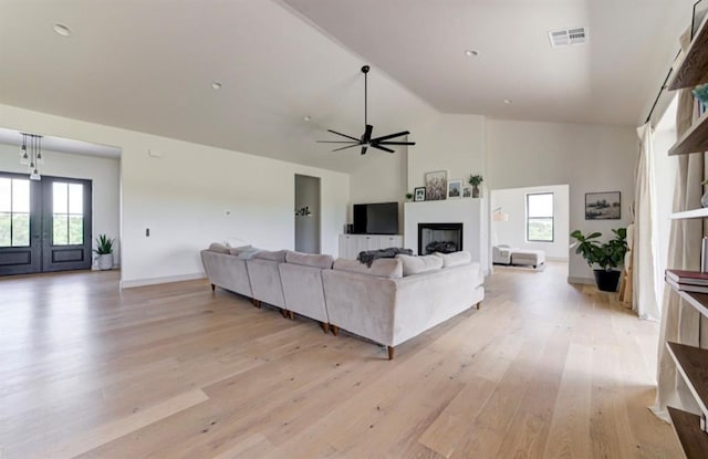 living room featuring french doors, light wood-type flooring, high vaulted ceiling, and ceiling fan