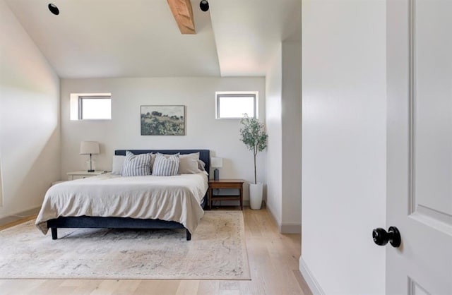 bedroom featuring multiple windows, light hardwood / wood-style floors, and lofted ceiling