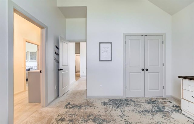 unfurnished bedroom with lofted ceiling, light wood-type flooring, and a closet