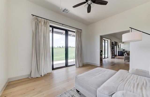 living room featuring ceiling fan and light wood-type flooring