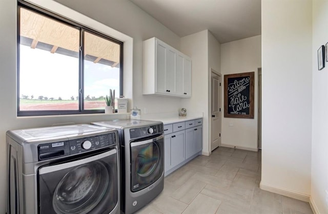 clothes washing area with cabinets and independent washer and dryer