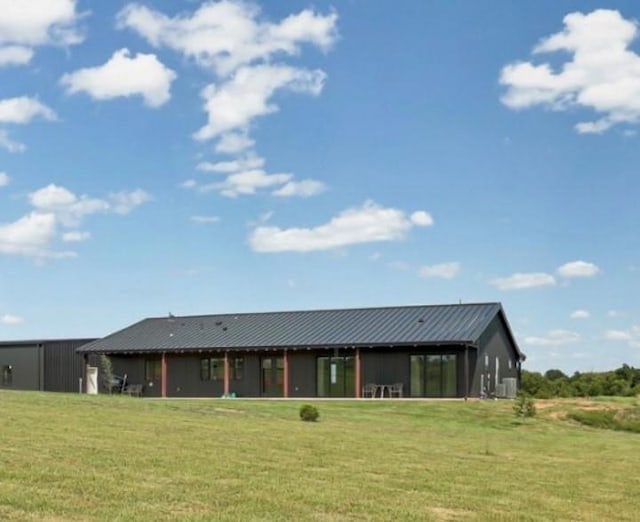 rear view of house featuring a yard