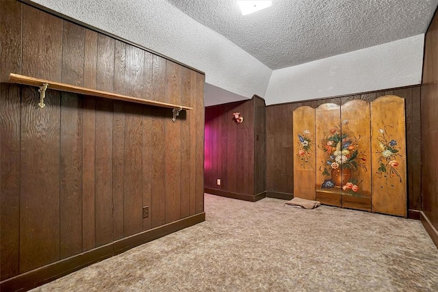 interior space with wood walls, light colored carpet, and a textured ceiling