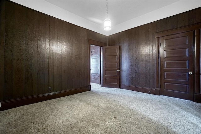 carpeted empty room with wooden walls