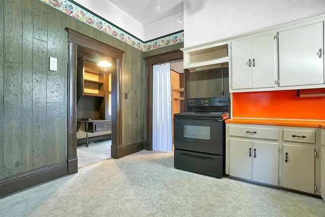 kitchen with a textured ceiling, white cabinetry, black range with electric stovetop, and light colored carpet